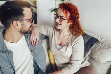 Genç mutlu çift evde komik bir şeyler anlatırken eğleniyor.