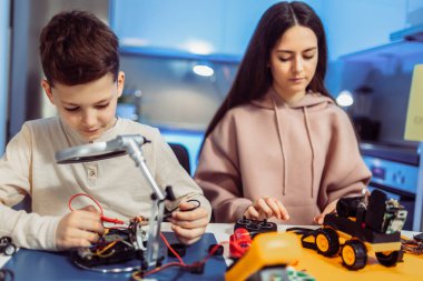 Küçük kız ve erkek kardeş çekimleri. Birlikte vakit geçirip robot yaparken. 