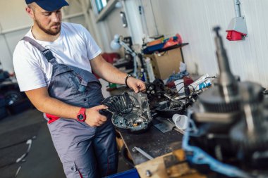 Atölye garajında kontrol ve servis arabası üzerinde çalışan teknisyen; araba servisinde otomobilin teknisyen onarımı ve bakım motoru