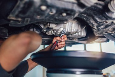 Garajında araba tamir eden bir tamircinin portresi, yağ değişimi..