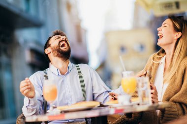 Genç bir çift restoranda oturmuş dışarıda pizza yiyorlar..