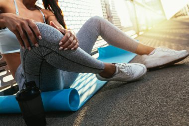 Yaralı koşucu acıyı azaltmak için bacağını tutuyor. Açık havada atlet eğitimi için koşma problemi