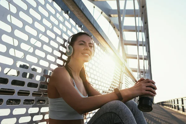 フィットネス女性の水のボトルを保持する 筋肉の若い女性が外のワークアウトから休憩を取って — ストック写真