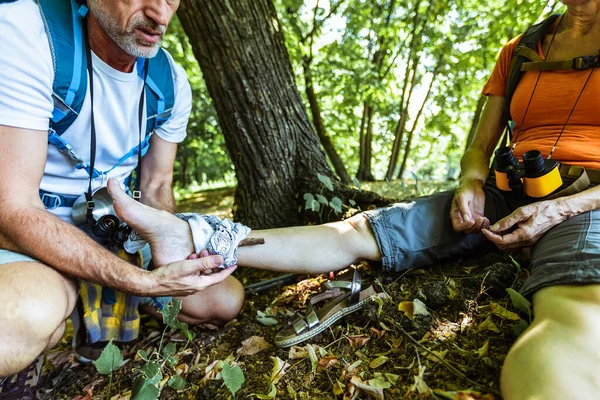 Caucasian Man Putting Bandage Injured Woman Leg Hiking Summer Nature — Stock Photo, Image