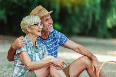 Şirin yaşlı çift nehir kenarında piknik yapıyor..