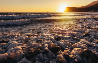 Adriyatik Denizi. Sahil. Dalgalar. Deniz köpüğü. Güneş ışığı.