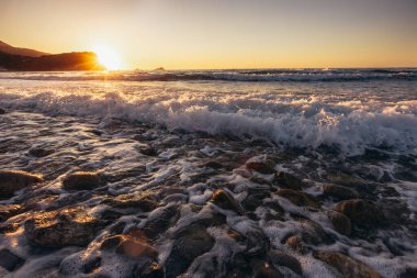 Adriyatik Denizi. Sahil. Dalgalar. Deniz köpüğü. Güneş ışığı.