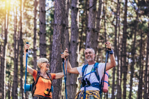 Starsza Para Wędrująca Lesie Plecakach Biegunach Turystycznych Nordic Walking Trekking — Zdjęcie stockowe