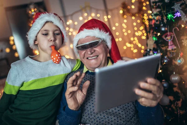 Grandfather Grandson Sitting Chair Looking Digital Tablet Christmas Senior Man — Zdjęcie stockowe