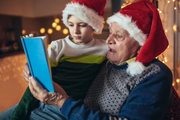 Grootvader Kleinzoon Zitten Stoel Lezen Boek Tijdens Kerst — Stockfoto