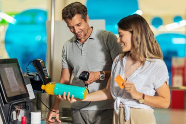 Banka kartı olan bir çift marketten ya da süpermarketten yiyecek alıyor.