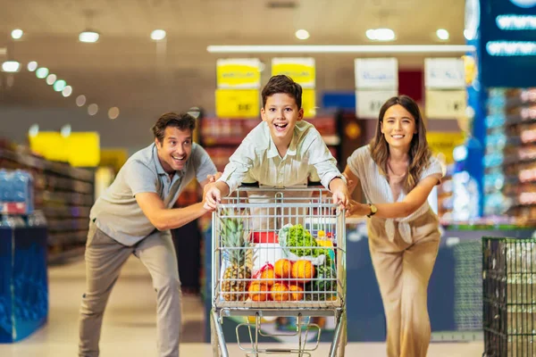 Familia Feliz Con Niño Carrito Compra Alimentos Tienda Comestibles Supermercado — Foto de Stock