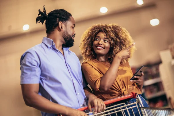 African American Couple Choosing Products Using Phone Grocery Shopping Modern — ストック写真