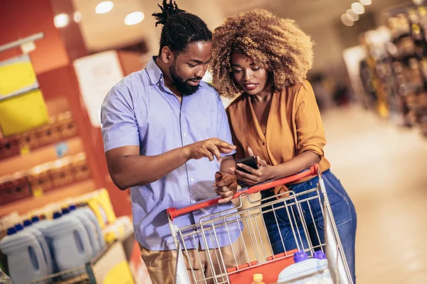 African American Couple Choosing Products Using Phone Grocery Shopping Modern — Stok fotoğraf