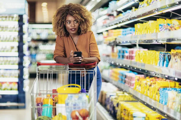 Афроамериканка Покупает Еду Продуктовом Магазине Используя Телефон — стоковое фото