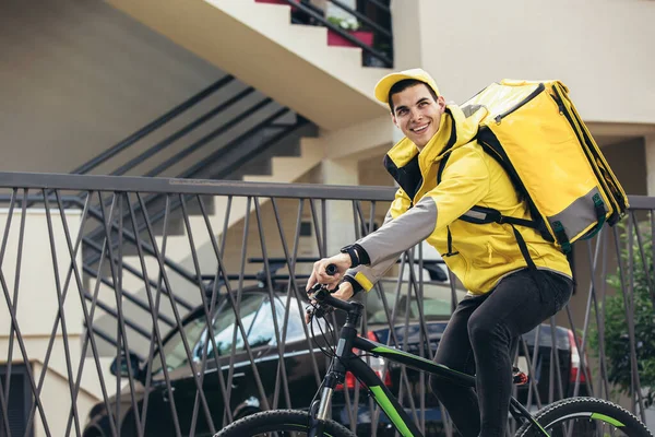 Bisikletli erkek kurye paket teslim ediyor.