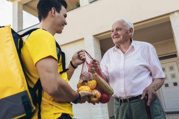 Joven Voluntario Entregando Compras Hombre Mayor Donación — Foto de Stock