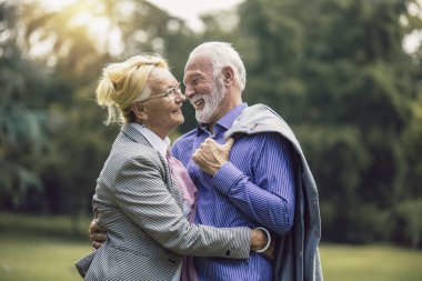 Parkta poz veren güzel yaşlı bir çiftin portresi.