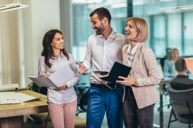 Group of young business people working together  while standing in creative office