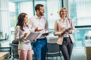 Group of young business people working together  while standing in creative office