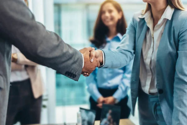 Business people shaking hands in the office. Group of business persons in business meeting. 