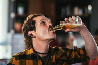 Evde arkadaşlarıyla öğrenci partisi veren biralı bir adamın portresi..