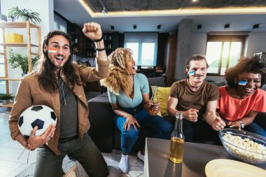 Genç bir grup televizyonda spor izliyor ve tezahürat yapıyor. Duygusal futbol hayranları evde futbol maçı izliyorlar. Boyalı Yüzlü Spor Hayranları TV 'de Kanepe İzleme Oyunu' nda oturuyor