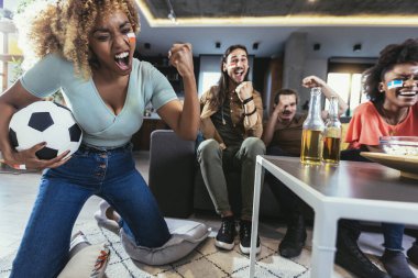 Genç bir grup televizyonda spor izliyor ve tezahürat yapıyor. Duygusal futbol hayranları evde futbol maçı izliyorlar. Boyalı Yüzlü Spor Hayranları TV 'de Kanepe İzleme Oyunu' nda oturuyor