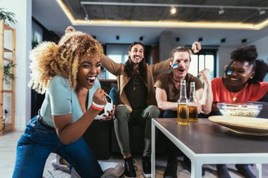 Genç bir grup televizyonda spor izliyor ve tezahürat yapıyor. Duygusal futbol hayranları evde futbol maçı izliyorlar. Boyalı Yüzlü Spor Hayranları TV 'de Kanepe İzleme Oyunu' nda oturuyor