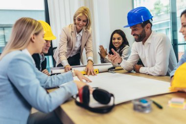 Mimarlar, tasarımcılar ve mühendisler modern ofiste çalışma toplantısı yapıyorlar.