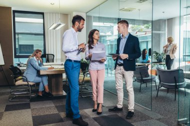 Group of young business people working together while standing in creative office