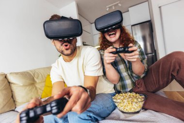 Sanal yolculuk. Sanal gerçeklik gözlüğü takan genç çift sanal gerçeklik kamerasıyla hayal kuruyor ve izliyorlar.