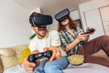 Sanal yolculuk. Sanal gerçeklik gözlüğü takan genç çift sanal gerçeklik kamerasıyla hayal kuruyor ve izliyorlar.