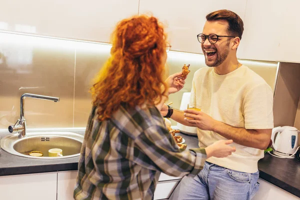 家で朝食を食べながらクロワッサンを食べるカップル — ストック写真