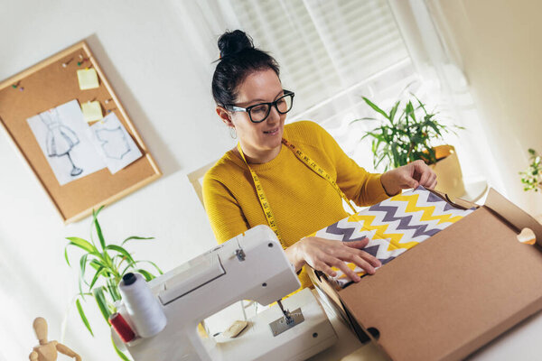 Sales Online. Working woman at their store. They accepting new orders online and packing merchandise for customer.