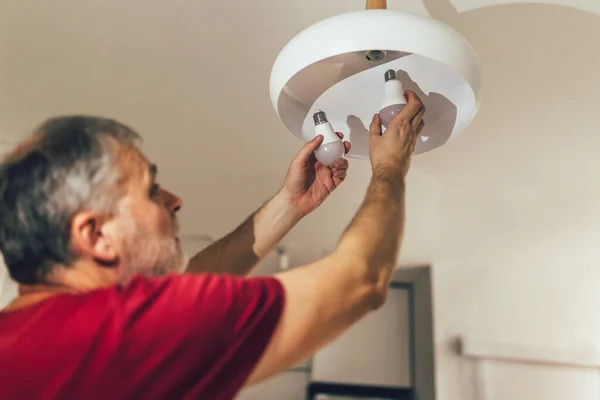 Een Man Die Een Gloeilamp Ververst Zijn Huis — Stockfoto