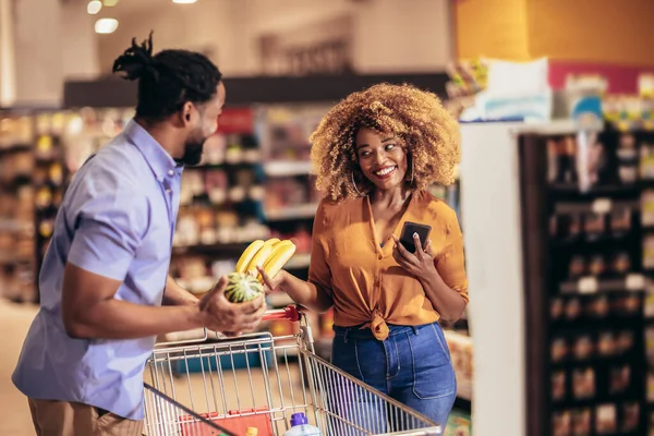Афро Американская Пара Выбирает Продукты Помощью Телефона Время Покупок Супермаркете — стоковое фото