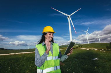 Elektrik üretimi için yel değirmeni çiftliğinde kadın mühendis.