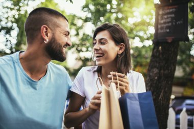 Alışveriş sonrası kahve molası. Çift aşk kafede kahve içme ve birbirleriyle yeni satın alma paylaşımı.