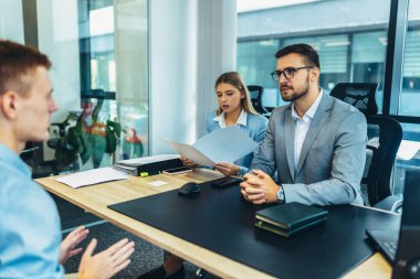 Human resource team talking to a candidate during a job interview in the office.