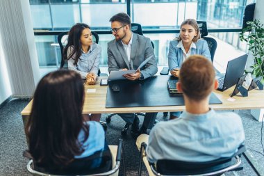 Human resource team talking to a candidate during a job interview in the office.