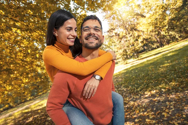 Pareja Sonriente Divirtiéndose Parque Otoño Novio Llevando Novia Cuestas — Foto de Stock