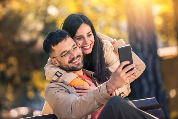 Unga Par Sitter Bänk Parken Och Göra Selfie Foto Med — Stockfoto