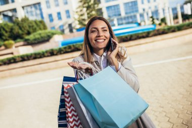 Çekici bir genç kadının şehirde alışverişe çıkması.