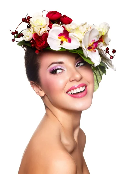 Sorridente donna bruna con fiori colorati sulla testa Fotografia Stock