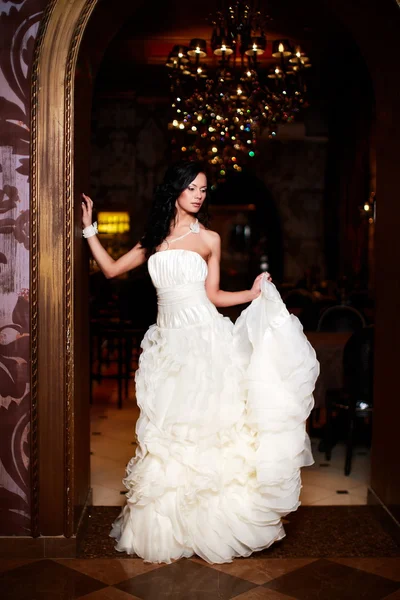 Felice bella sposa sexy ragazza bruna donna in abito da sposa bianco con acconciatura e trucco luminoso all'interno — Foto Stock