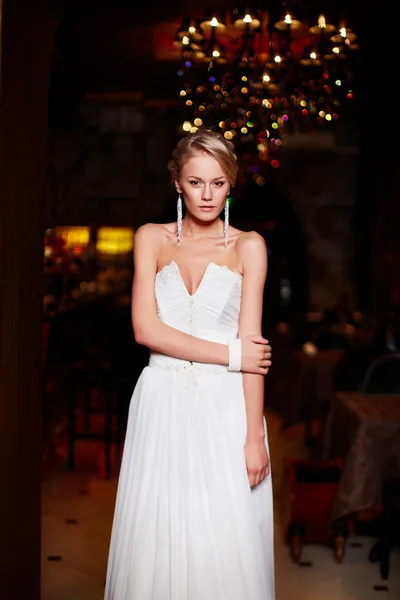 Felice bella sposa sexy donna bionda ragazza in abito da sposa bianco con acconciatura e trucco luminoso all'interno — Foto Stock