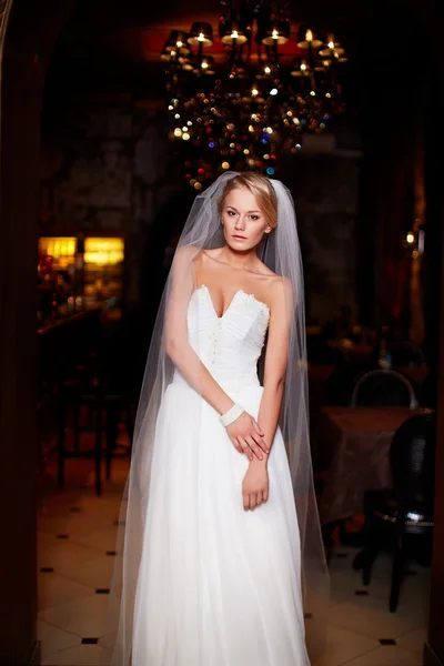 Felice bella sposa sexy donna bionda ragazza in abito da sposa bianco con acconciatura e trucco luminoso all'interno — Foto Stock