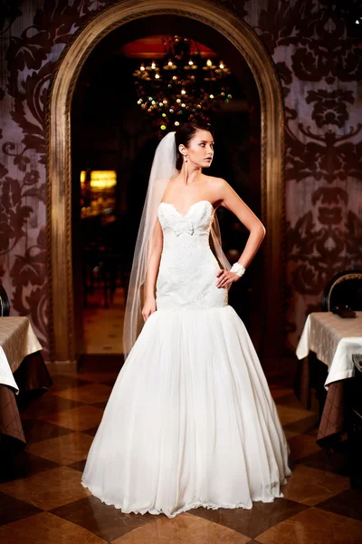 Felice bella sposa sexy ragazza bruna donna in abito da sposa bianco con acconciatura e trucco luminoso all'interno — Foto Stock