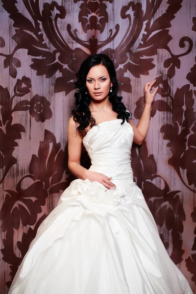 Felice bella sposa sexy ragazza bruna donna in abito da sposa bianco con acconciatura e trucco luminoso all'interno — Foto Stock